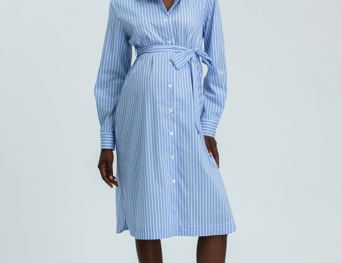 Woman wearing a blue and white striped dress on a white background