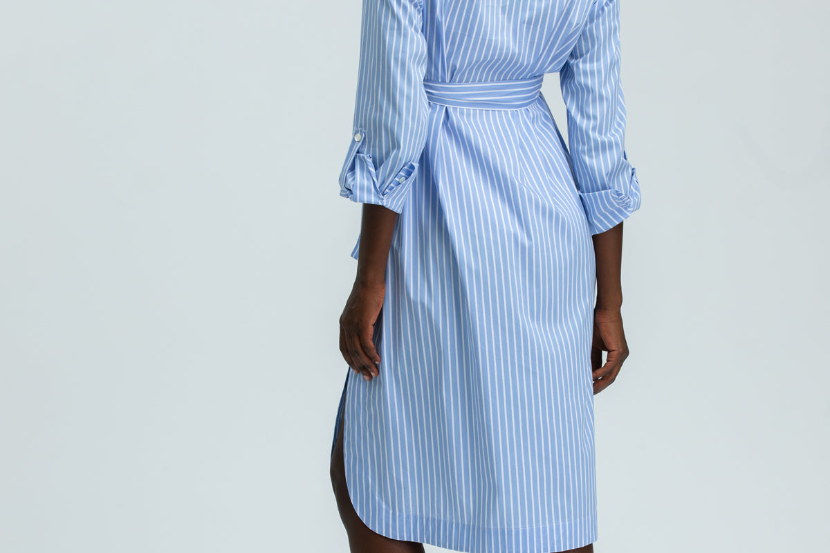Woman wearing a blue and white striped dress on a plain background