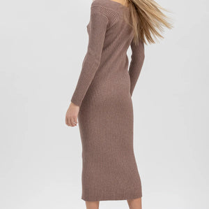 A woman modeling a ribbed knit long-sleeve midi dress in a muted taupe-brown color, paired with dark brown lace-up ankle boots, against a plain light gray studio background.