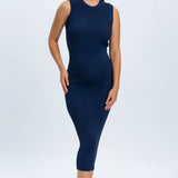 Woman wearing a navy blue sleeveless dress on a white background