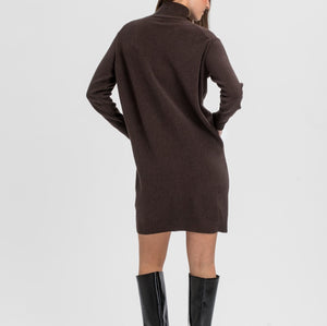 A woman shown from the back wearing a dark brown long-sleeve knit dress with a mock neck and black knee-high heeled boots, photographed against a light gray studio background.