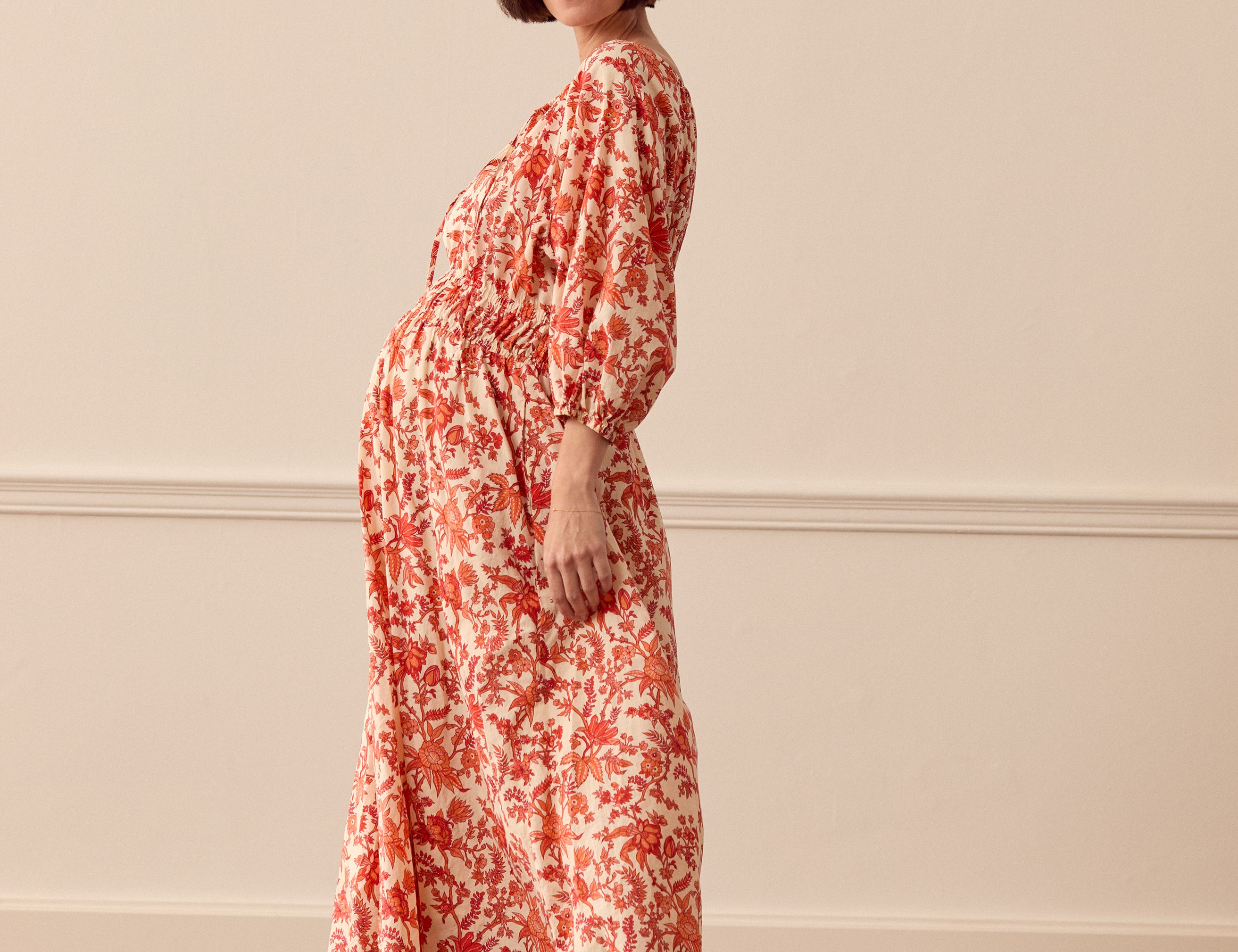 Albaray cream midi dress with orange botanical print, made from 100% organic cotton. Features a gathered tie neckline, ¾ sleeves, elasticated waist, and lined skirt with pockets – ideal for everyday comfort and effortless style.