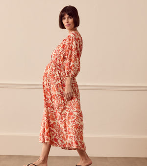 Albaray cream midi dress with orange botanical print, made from 100% organic cotton. Features a gathered tie neckline, ¾ sleeves, elasticated waist, and lined skirt with pockets – ideal for everyday comfort and effortless style.