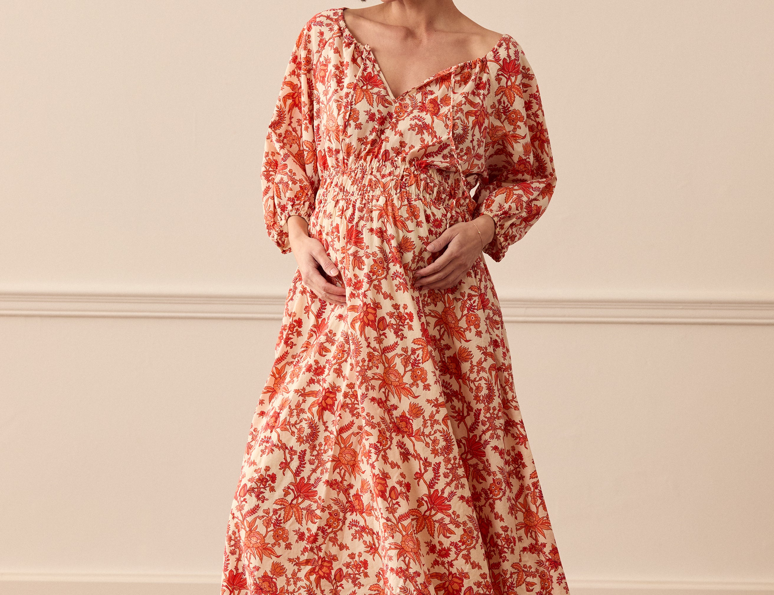 Albaray cream midi dress with orange botanical print, made from 100% organic cotton. Features a gathered tie neckline, ¾ sleeves, elasticated waist, and lined skirt with pockets – ideal for everyday comfort and effortless style.