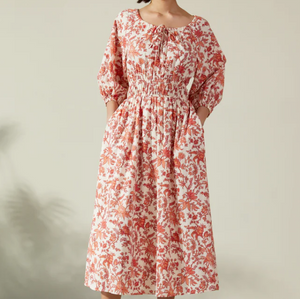 Albaray cream midi dress with orange botanical print, made from 100% organic cotton. Features a gathered tie neckline, ¾ sleeves, elasticated waist, and lined skirt with pockets – ideal for everyday comfort and effortless style.