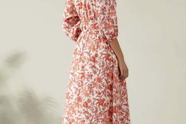 Albaray cream midi dress with orange botanical print, made from 100% organic cotton. Features a gathered tie neckline, ¾ sleeves, elasticated waist, and lined skirt with pockets – ideal for everyday comfort and effortless style.