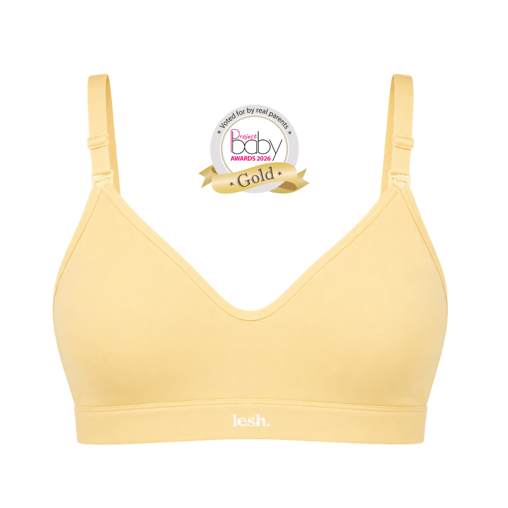 A pale yellow V-neck bralette with adjustable shoulder straps and a wide underband, shown on a plain white background with a 'Best of Baby Awards 2025 Gold' badge above it.