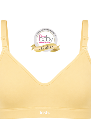 A pale yellow V-neck bralette with adjustable shoulder straps and a wide underband, shown on a plain white background with a 'Best of Baby Awards 2025 Gold' badge above it.