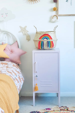 Vivid Rainbow Belly Basket on top of a pale pink locker beside a child's bed with star cushions