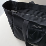 Black tote bag with 'Tiba + Marl' label on a white background