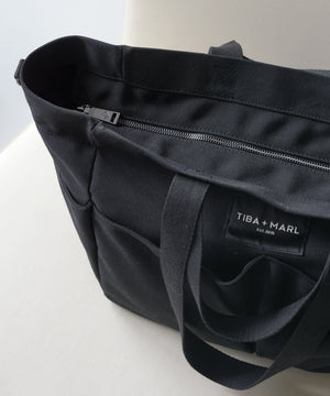 Black tote bag with 'Tiba + Marl' label on a white background