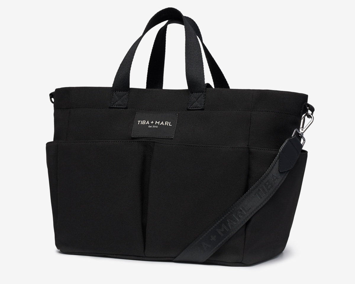 Black tote bag with a visible brand label on a white background