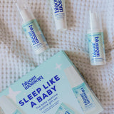 Blossom Sleep Like a Baby routine gift set including a box, spray bottle, tube, and pump bottle, arranged on a white textured blanket.