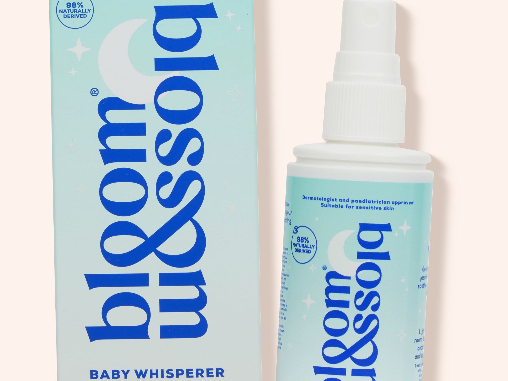 Blossom & Soho Baby Whisperer calming baby sleep spray shown with its light blue and white packaging box and spray bottle on a pale pink background.