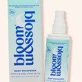 Blossom & Soho Baby Whisperer calming baby sleep spray shown with its light blue and white packaging box and spray bottle on a pale pink background.