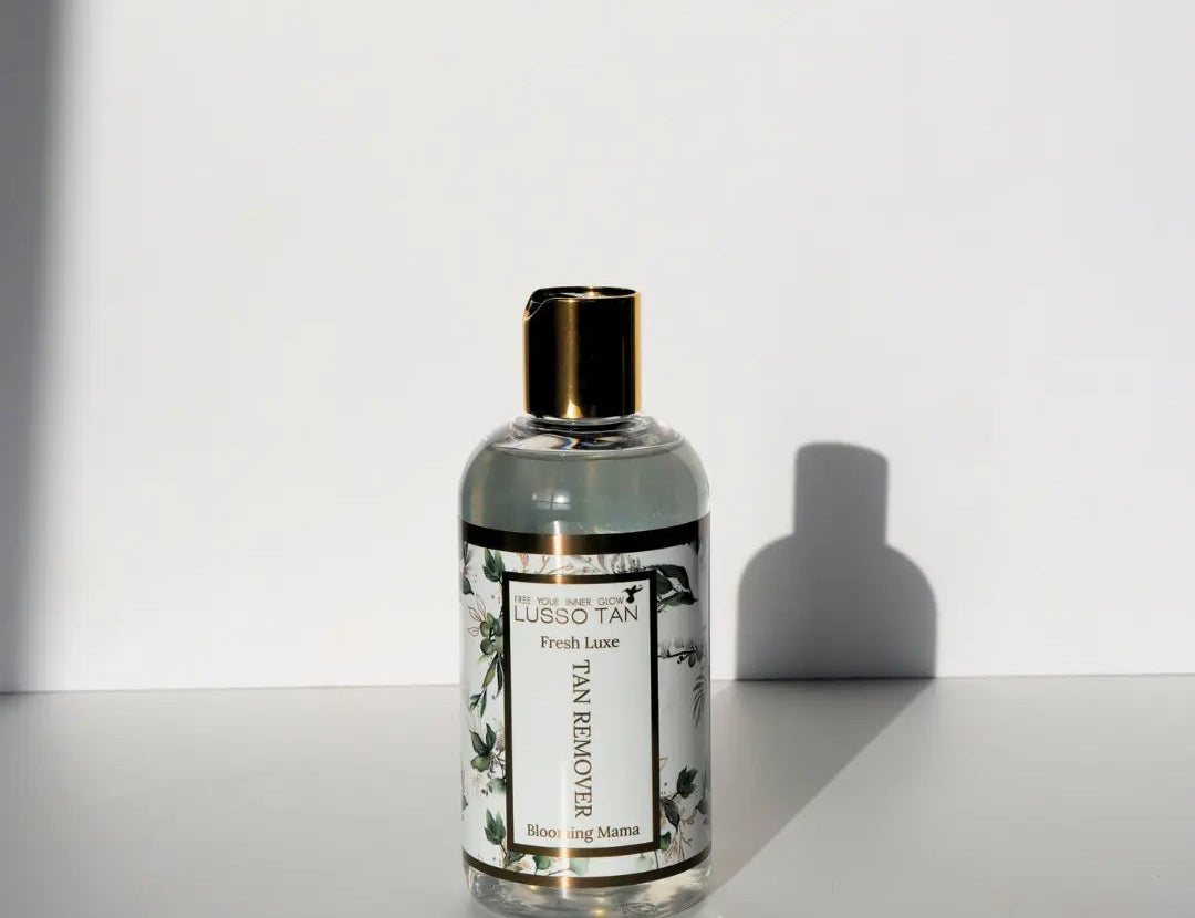 Fresh Lux Tan Removing Shower Gel bottle with gold cap against a white wall, with a hard-edged shadow beside it