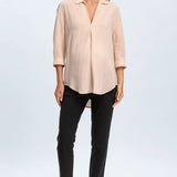 Woman wearing a beige blouse and black pants on a white background