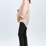 Woman wearing a beige blouse and black pants on a white background