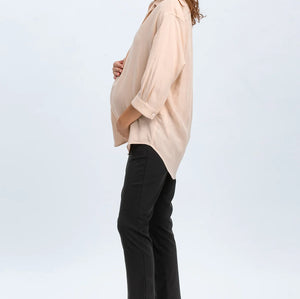 Woman wearing a beige blouse and black pants on a white background