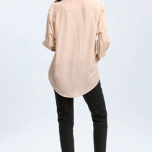 Woman wearing a beige shirt and black pants on a white background