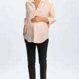 Woman wearing a beige blouse and black pants on a white background