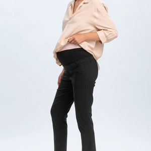 Woman wearing a beige blouse and black pants on a white background