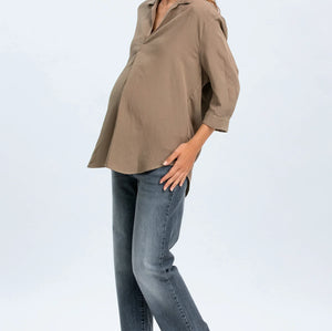 Woman wearing a brown blouse and blue jeans on a white background