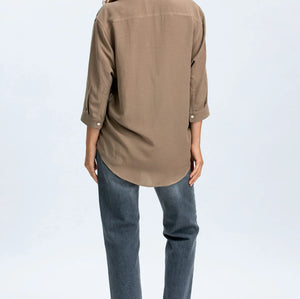 Woman wearing a brown shirt and blue jeans on a white background