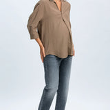 Woman wearing a beige blouse and blue jeans on a white background