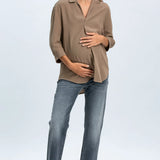 Woman wearing a beige blouse and blue jeans on a white background