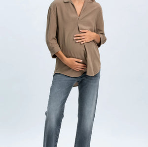 Woman wearing a beige blouse and blue jeans on a white background