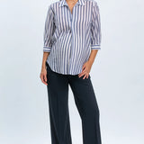Woman wearing a striped shirt and black pants on a white background