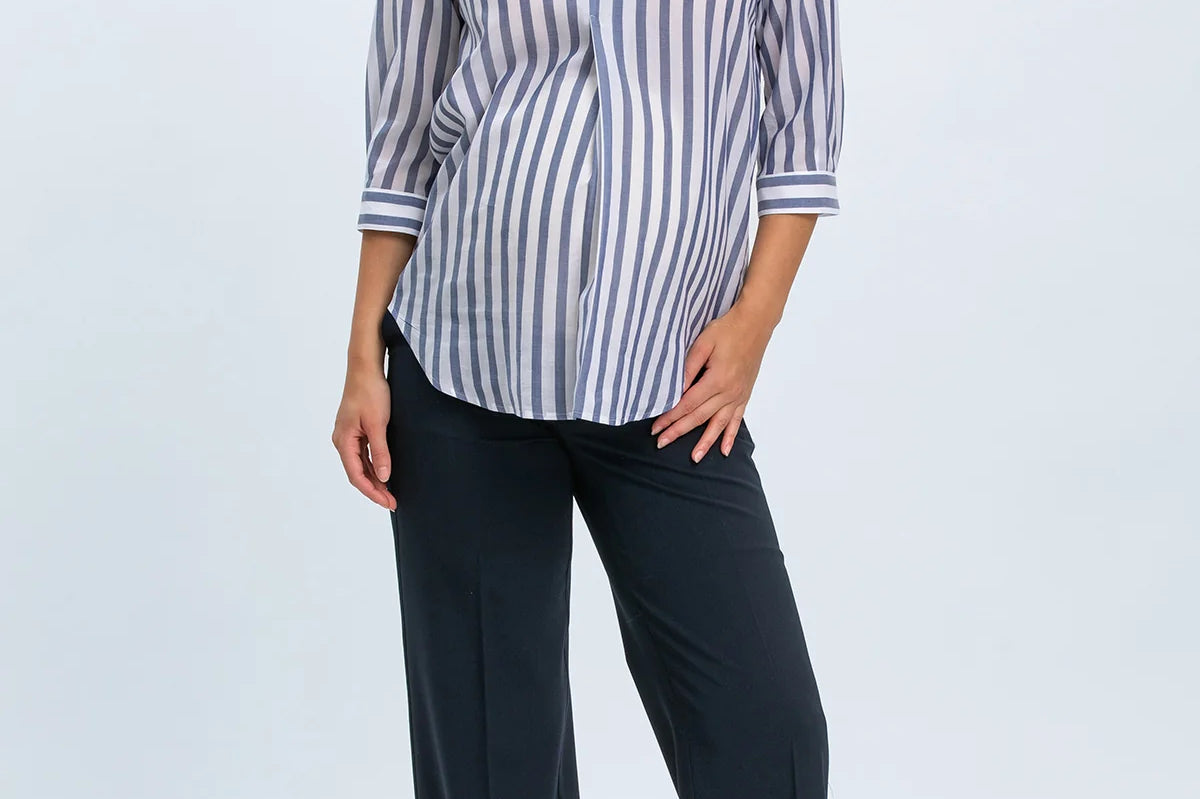 Woman wearing a striped shirt and black pants on a white background