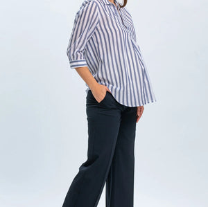 Woman wearing a striped shirt and dark pants on a white background