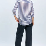 Woman wearing a striped shirt and dark pants on a white background