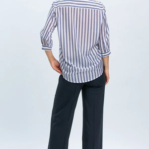 Woman wearing a striped shirt and dark pants on a white background