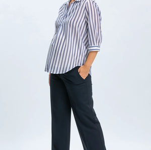 Woman wearing a striped shirt and navy pants on a white background