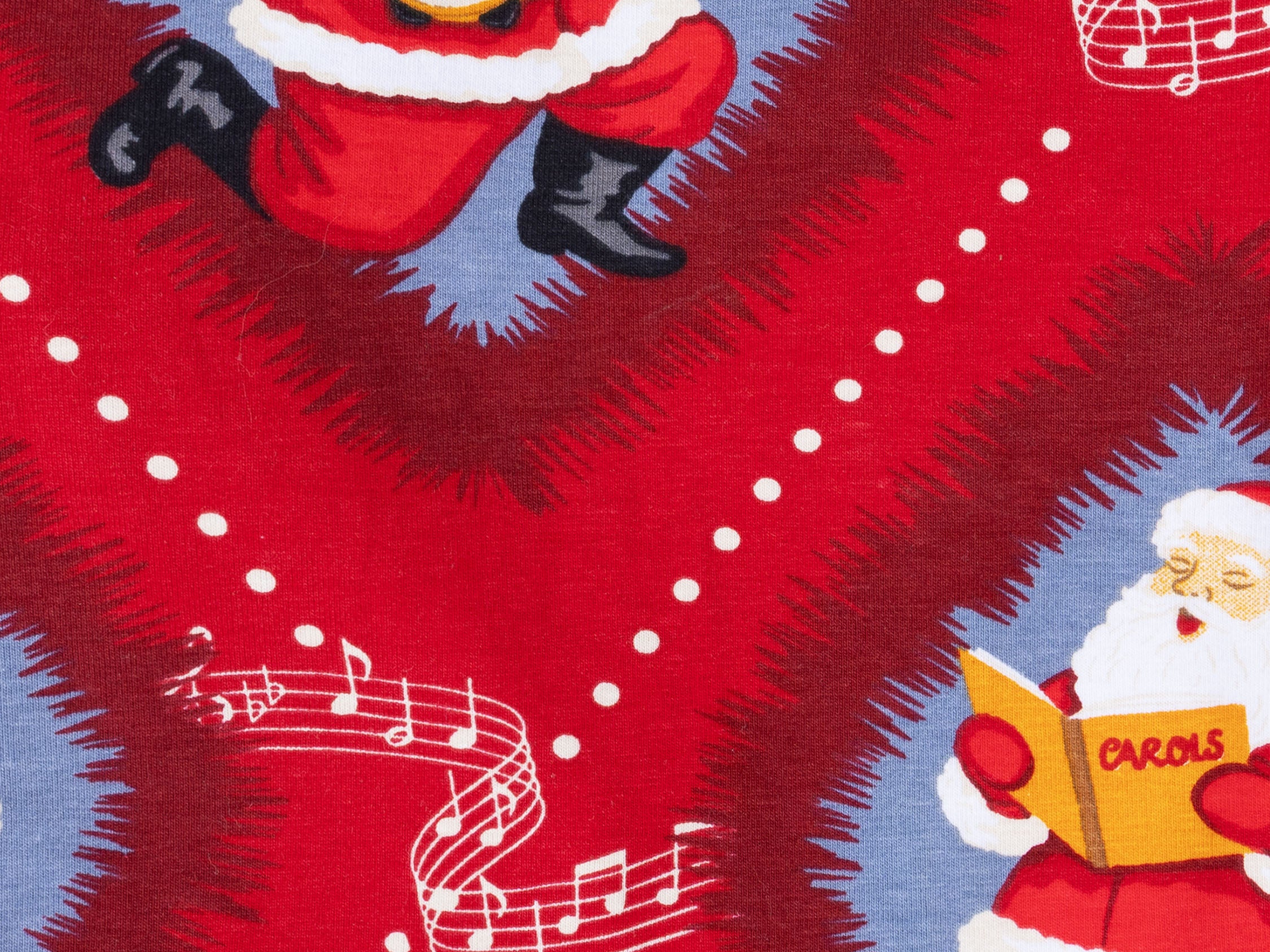 Red Christmas-themed fabric print featuring Santa Claus illustrations and white musical notes on a blue background.