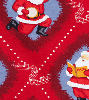 Red Christmas-themed fabric print featuring Santa Claus illustrations and white musical notes on a blue background.