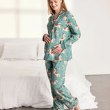 Woman wearing a teal pajama set with a dog pattern in a bedroom.