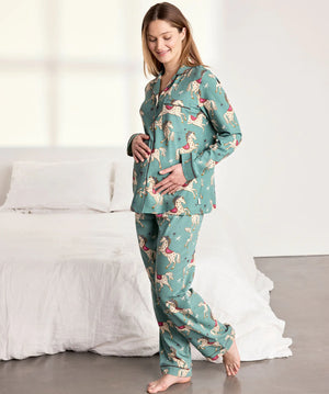 Woman wearing a teal pajama set with a dog pattern in a bedroom.