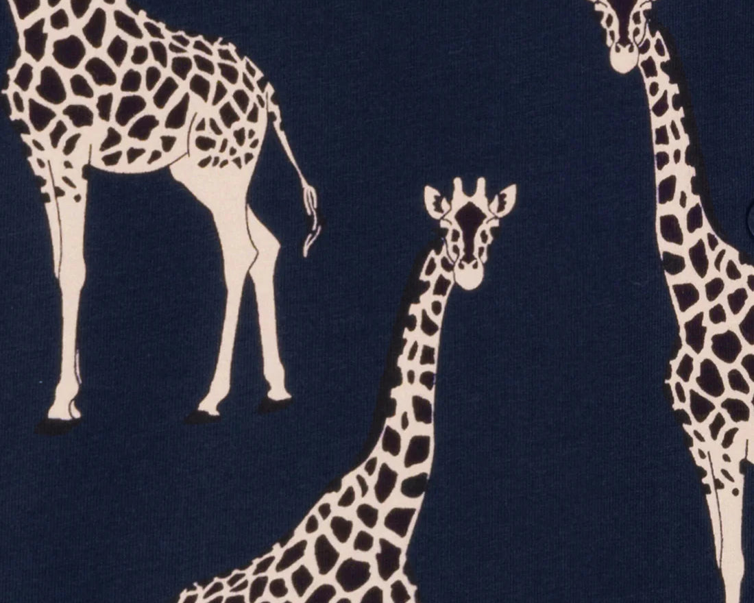 A close-up of a navy blue fabric with a repeating pattern of cream giraffes.