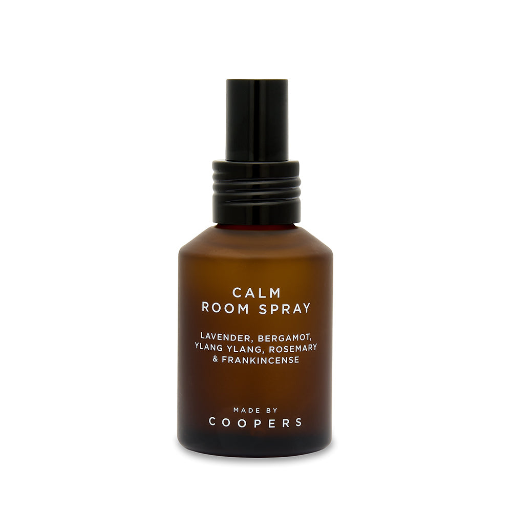 Calm Room Spray brown bottle with black pump, straight-on view showing the ingredients label on white