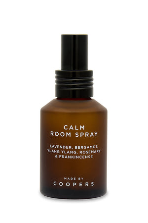 Calm Room Spray brown bottle with black pump, straight-on view showing the ingredients label on white