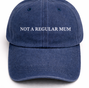 A navy blue cotton baseball cap with the phrase 'NOT A REGULAR MUM' embroidered in white capital letters across the front, shown against a plain white background.