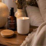 Sleepy Head Pillow Spray beside a lit Made by Coopers candle and its wooden lid on a bedside table
