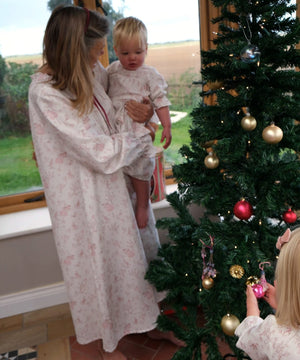 Baby Organic Cotton Nightie, Cordelia Toile: adult holding a baby in the nightie beside a Christmas tree, child hanging a bauble
