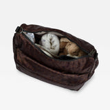 Clara Eco Changing Bag, Chocolate Leopard, top view with zip open showing a blanket and soft toy rabbit inside