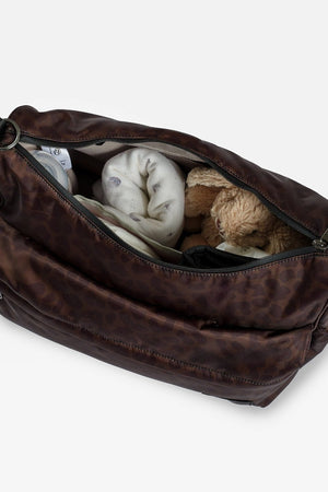 Clara Eco Changing Bag, Chocolate Leopard, top view with zip open showing a blanket and soft toy rabbit inside
