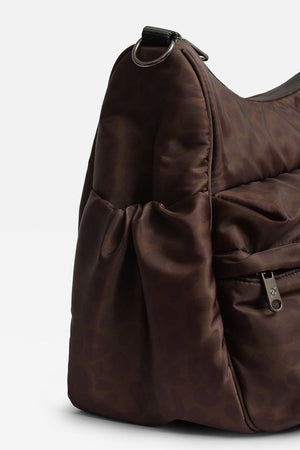 Clara Eco Changing Bag, Chocolate Leopard, close-up of the side pocket, front zip pocket and metal D-ring